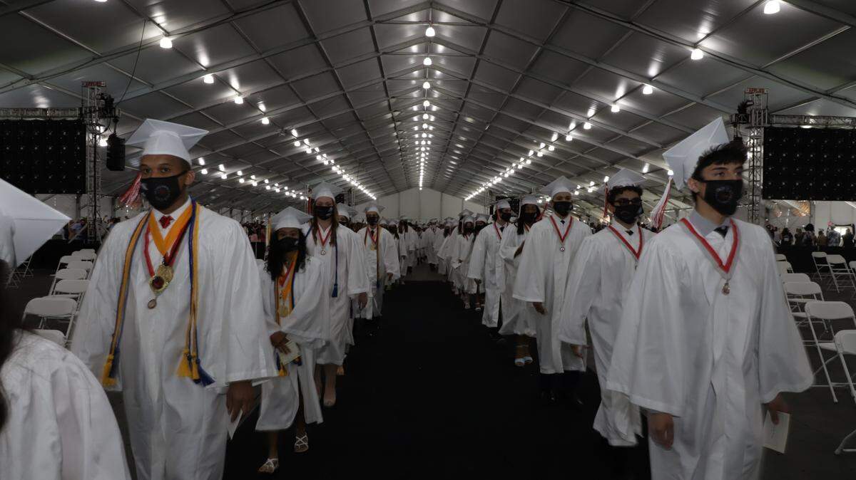 Coral Gables Senior High graduates march into the tent at the Miami-Dade Fair & Expo, 10901 Coral Way, on Tuesday, June 1, 2021, at the school’s 2021 graduation ceremony.