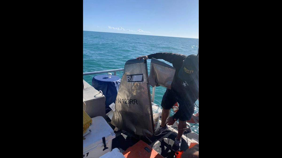 A Monroe County Sheriff’s Office diver holds a piece of aircraft debris that was found off the Florida Keys Thursday, March 3, 2021. Later that day, Coast Guard crews suspended the search for two people reported to be on the plane.