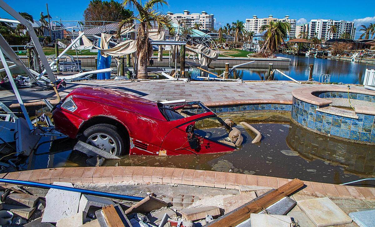 The front of a Mercedes Benz convertible sticks out of a pool in the back yard of a home on Estero Boulevard Wednesday, Oct. 26, 2022. The car ended up in the pool after Hurricane Ian slammed into the area as a Category 4 storm Wednesday, Sept. 28, 2022.