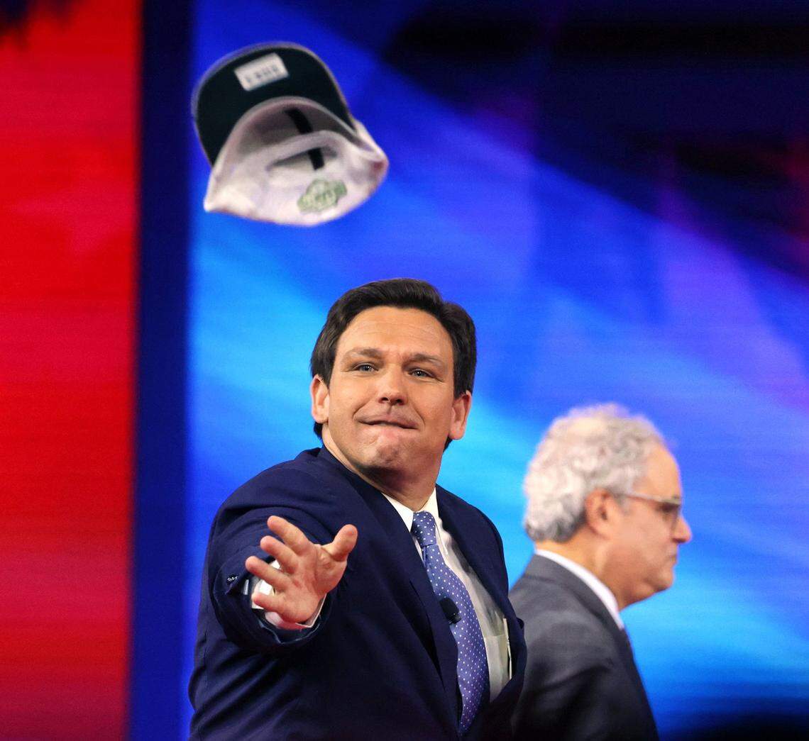 Florida Governor Ron DeSantis tosses hats into the crowd as he takes the stage at the 2022 CPAC conference at the Rosen Shingle Creek in Orlando, Fla., Thursday, Feb. 24, 2022.