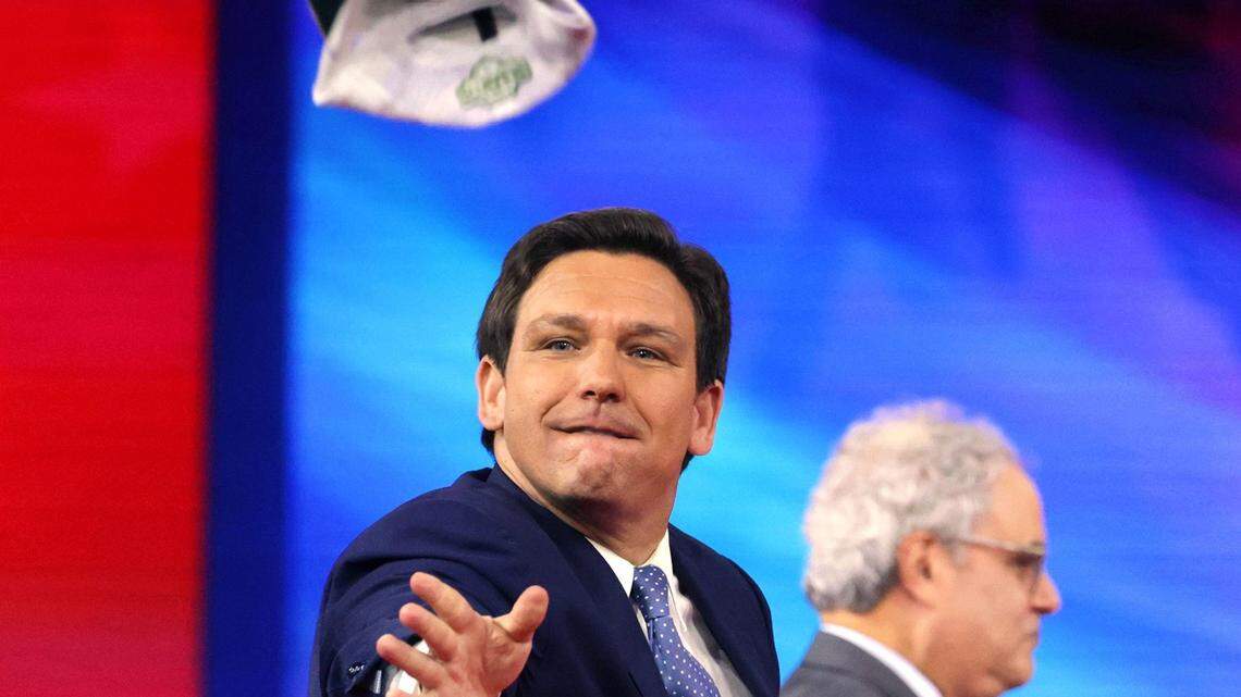 Florida Gov. Ron DeSantis tosses hats into the crowd as he takes the stage at the 2022 CPAC conference at the Rosen Shingle Creek in Orlando, Florida, Thursday, Feb. 24, 2022.