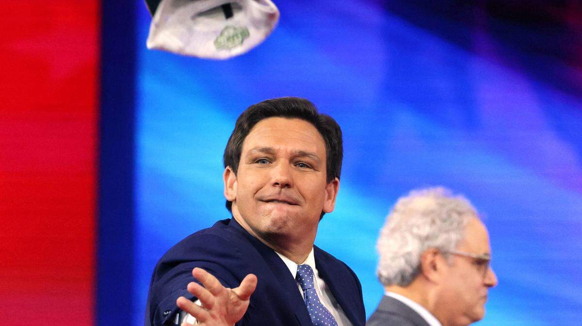 Florida Gov. Ron DeSantis tosses hats into the crowd as he takes the stage at the 2022 CPAC conference at the Rosen Shingle Creek in Orlando, Florida, Thursday, Feb. 24, 2022.