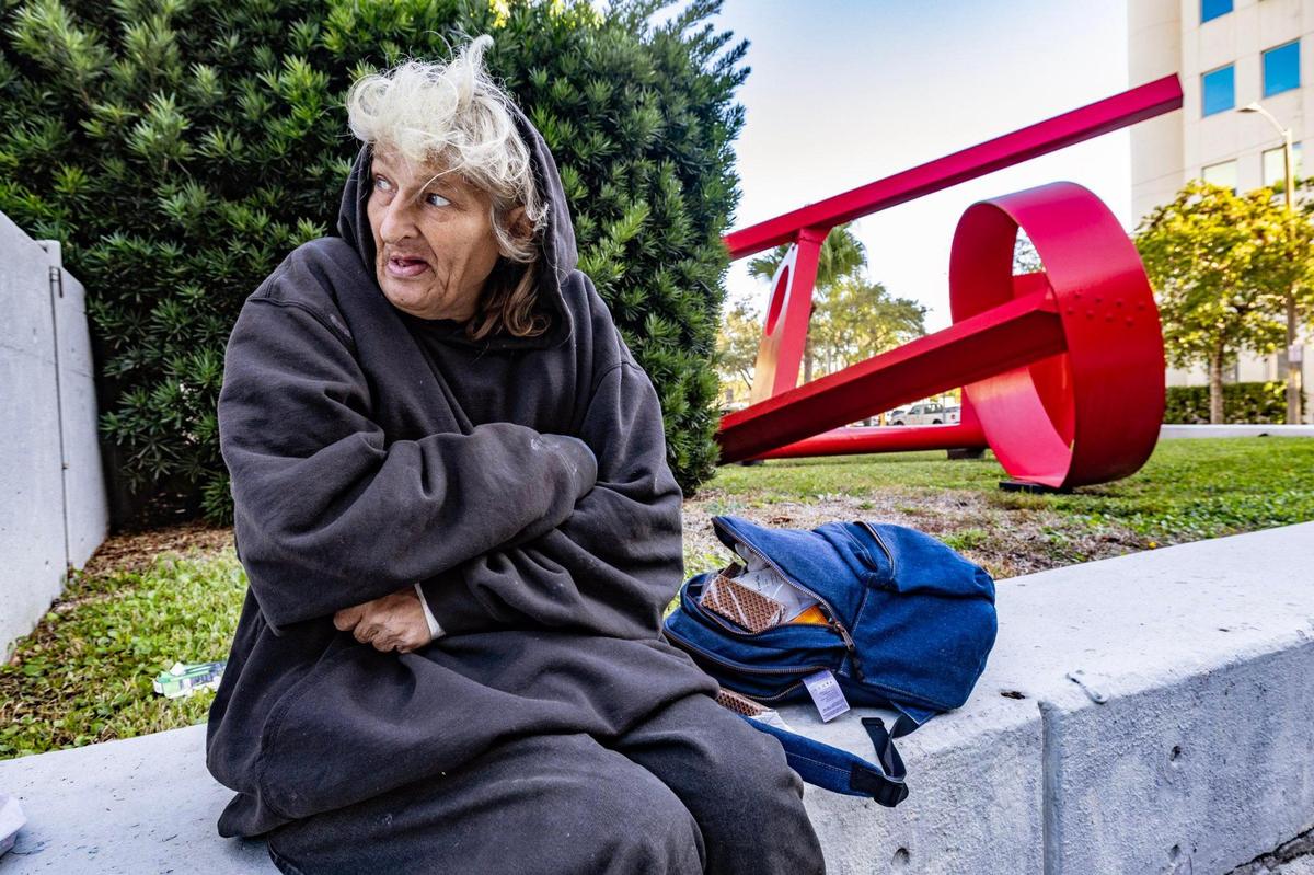 Jan Reed sits along Coral Way while attempting to stay warm as temperatures dipped to the low-50s, the coldest air of the season ain South Florida, on Wednesday morning, Jan. 8, 2025.
