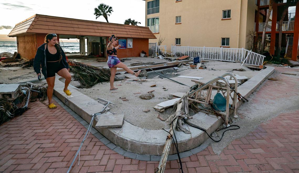 Ally Ronan and Alex Hunter check out the pool filled with beach sand caused by the storm surge from hurricanes Helene and Milton at Fisherman’s Cove beach front condominium rentals on Siesta Key, Florida on Thursday, October 10, 2024.