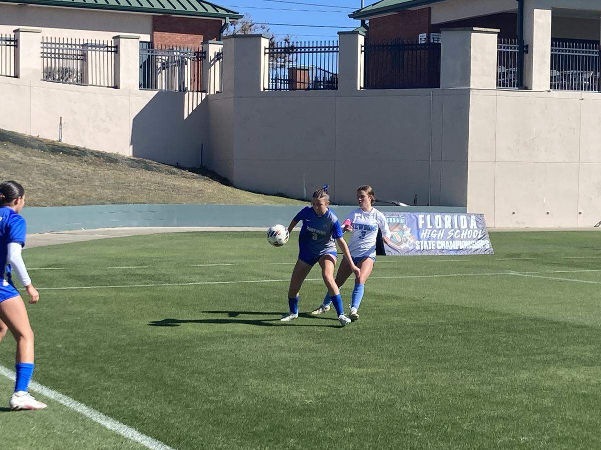 Cypress Bay forward Mackenzie Rector (left) battles Newsome defender Emma Poirier for possession in the corner. Rector recorded a hat trick, scoring all three of her team’s goals in Tuesday’s Class 7A state girls’ soccer semifinal at SpecMartin Stadium in DeLand, Fla.