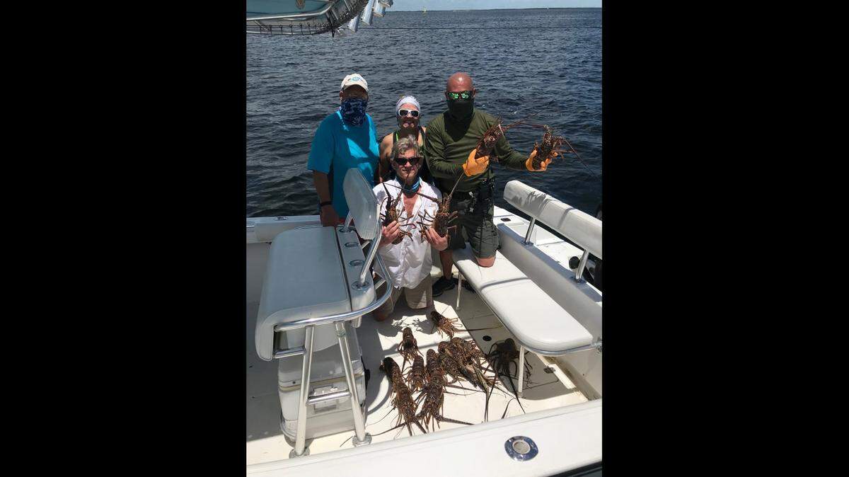 A Monroe County Sheriff’s Office Facebook page from July 29, 2020, shows Detective Sgt. Scott Ward holding spiny lobsters and posing with anglers after conducting a resource check during last year’s lobster miniseason. The sheriff’s office accused Ward Thursday, July 29, 2021, of stealing six lobsters during a similar resource check last year.