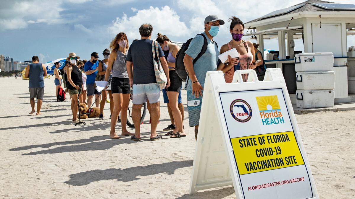 People line up to receive a Johnson & Johnson vaccine at the pop-up vaccination site at 16th Street beach on the sand on Sunday, May 2, 2021, in Miami Beach. The one-time vaccination site, made possible by Miami Beach Commissioner David Richardson and the Florida Division of Emergency Management, had up to 250 Johnson & Johnson shots to administer.