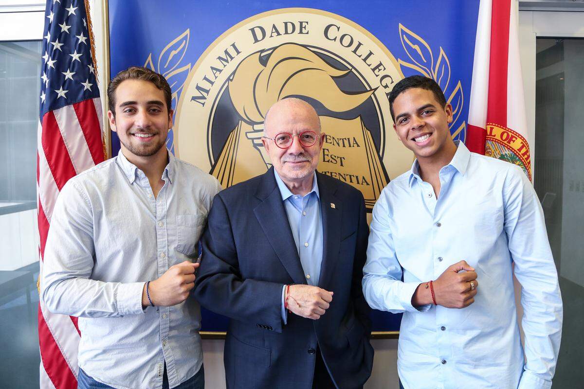 Bryan Montes, left, and Shawn Torres, right, were named recipients of the 2018 Florida Campus Compact Social Entrepreneurship Award for their social venture called Bracelets for Commitment. The students show off their bracelets with Miami Dade College President Eduardo Padron.