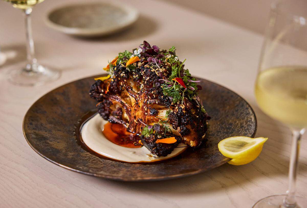 Charred cauliflower with tahini cashew puree, sesame chili crisp, fruikake and herbs at Salt and Ash at Hawks Cay Resort.