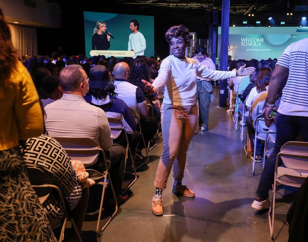 A VOUS volunteer welcomes congregants in Miami Gardens during Palm Sunday service. VOUS opened their fourth location in January 2024 and continues to thrive in a era when many legacy churches are struggling to attract members.