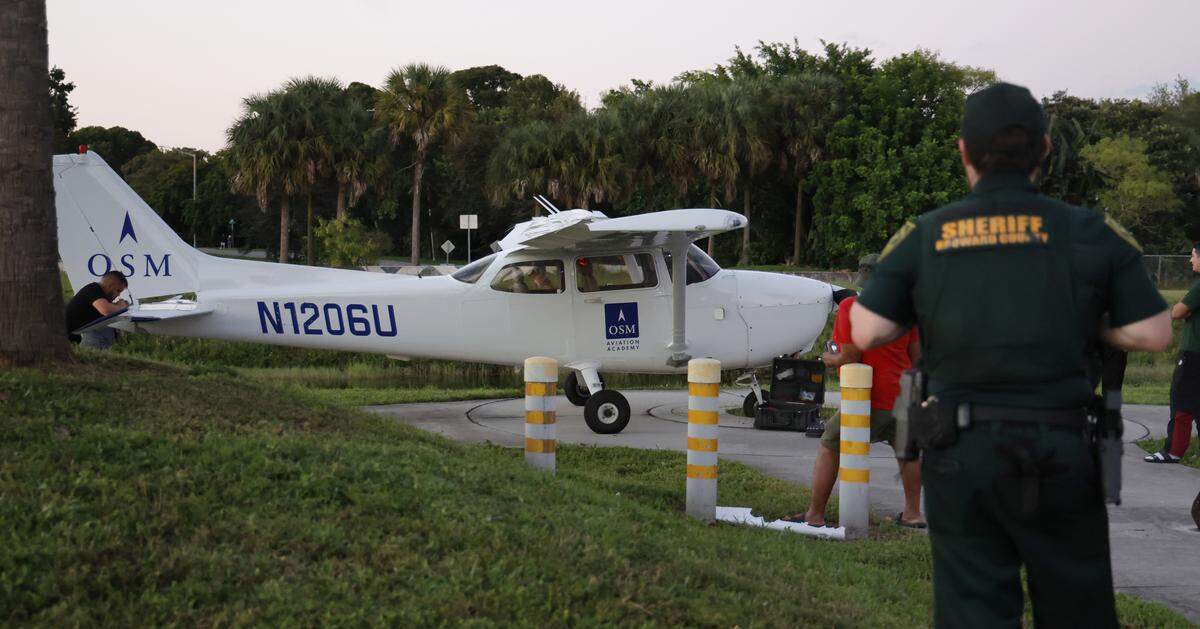 A small plane rests after making an emergency landing near the Cypress Creek Canal in North Lauderdale on Monday, Oct. 13, 2025. (Carline Jean/South Florida Sun Sentinel)