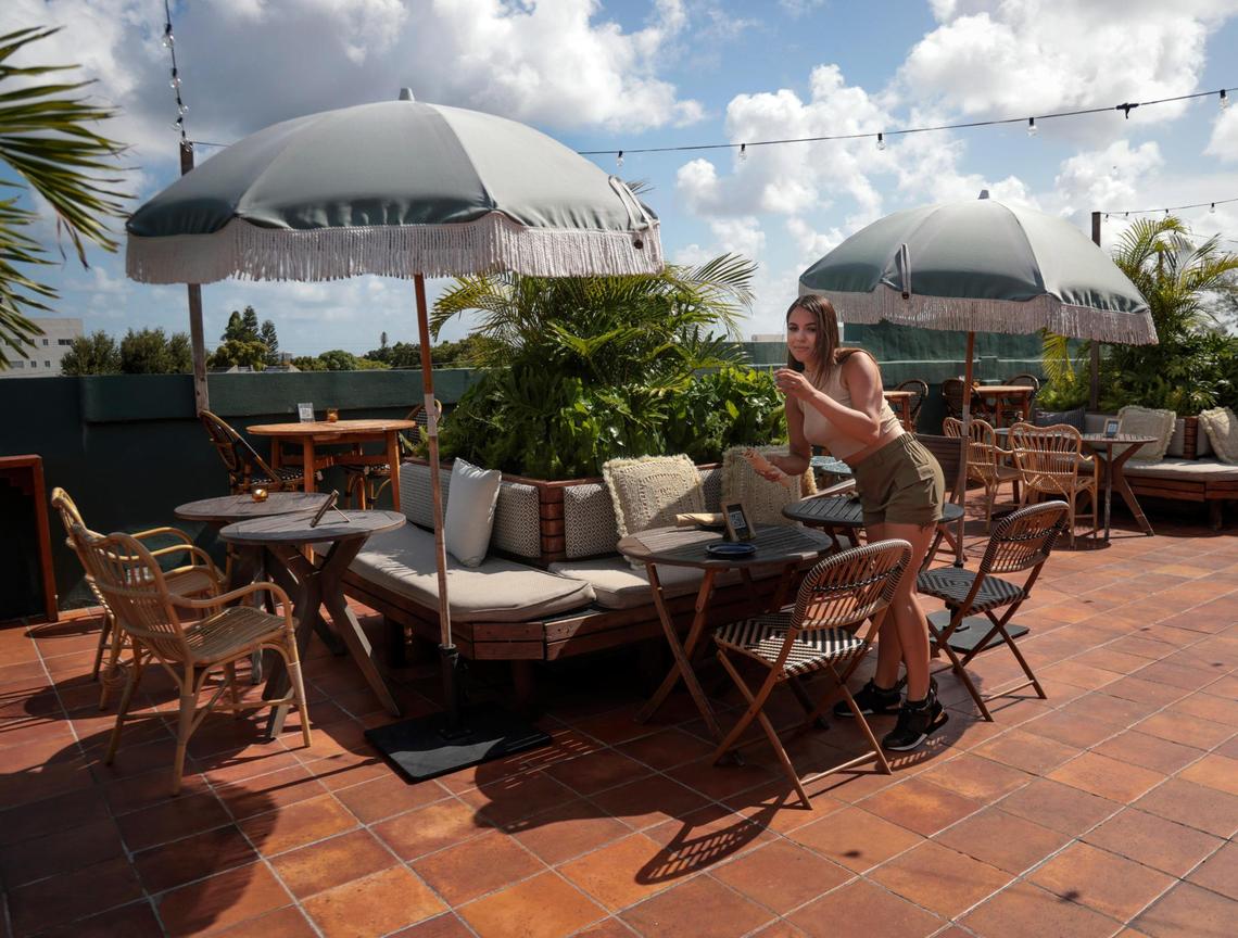 Bartender and server Dalianny Mandiarote sets a table at the rooftop bar of the boutique hotel, Life House Little Havana, on Thursday, July 14, 2022. Destinations similar to the Life House Little Havana offer tourists and locals art and culture as Miami’s image pivots away from “party town.”