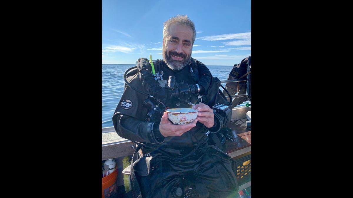 Wreck diver Joe Mazraani, seen her with an artifact pulled from a shipwreck, died while diving a wreck off Cape Cod, his crew says. 