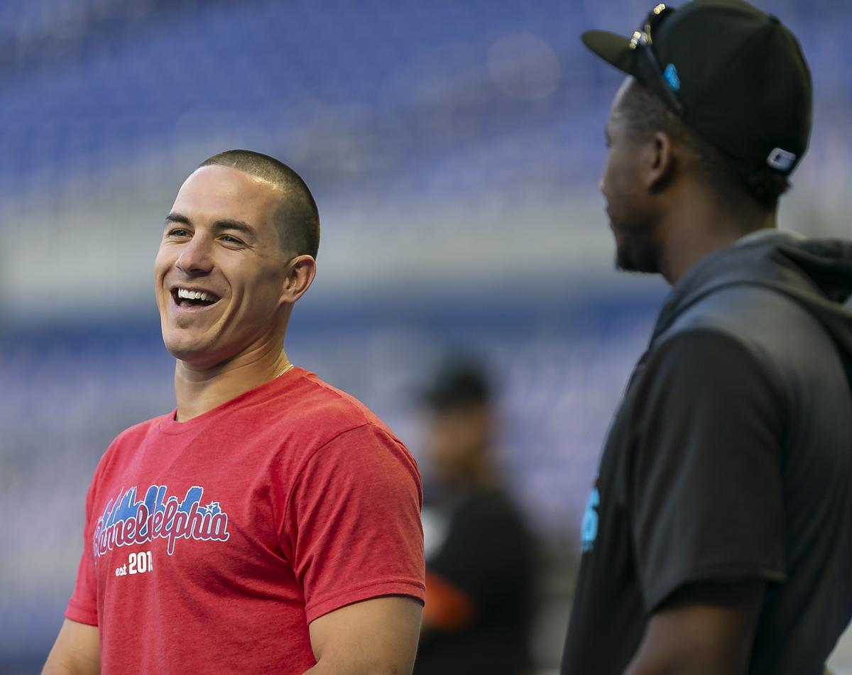 Philadelphia Phillies catcher J.T. Realmuto (10) talks with his former teammate Miami Marlins Lewis Brinson (9) before playing against each other in a regular season baseball game at Marlins Park in Miami on Friday, April 12, 2019.