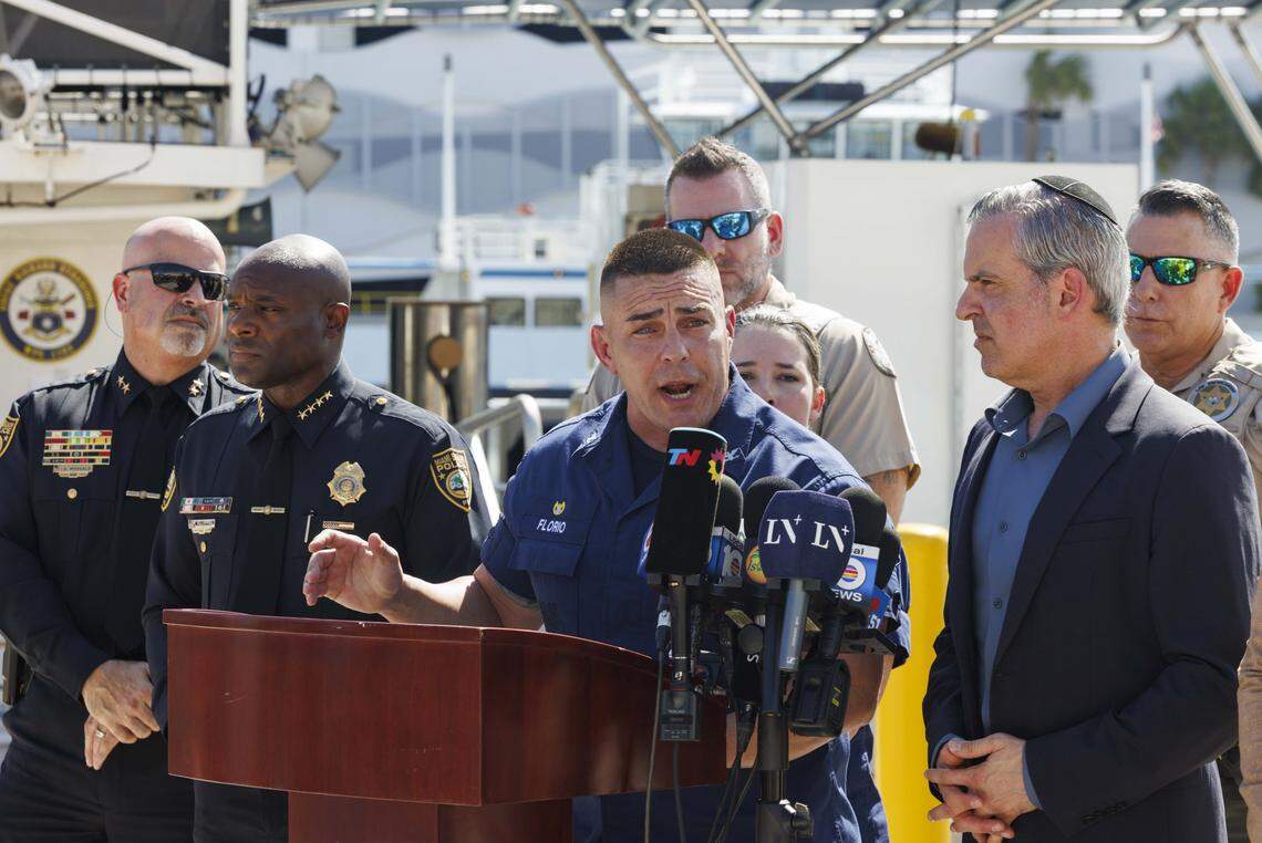 Capt. Frank Florio III, commander of U.S. Coast Guard Sector Miami, center, updates the media Tuesday about its investigation into Monday’s boat crash in Biscayne Bay. A 60-foot barge pushed by a tugboat crashed into a 17-foot sailboat carrying five girls and a camp counselor from the Miami Yacht Club, off Hibiscus Island in Miami Beach. Two girls died and two are in critical condition at Jackson Memorial Hospital, officials said.