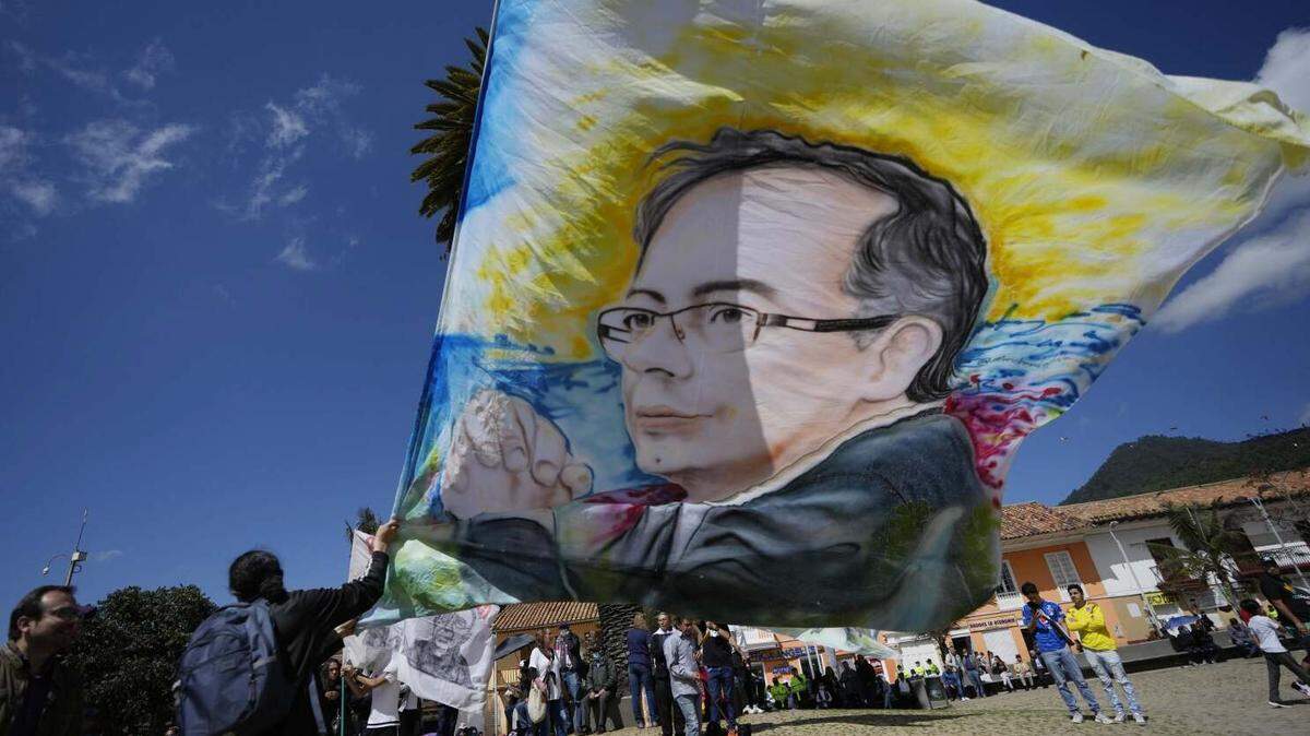 Supporters wave a flag with the image of Gustavo Petro, who will assume Colombia’s presidency on Aug. 7.
