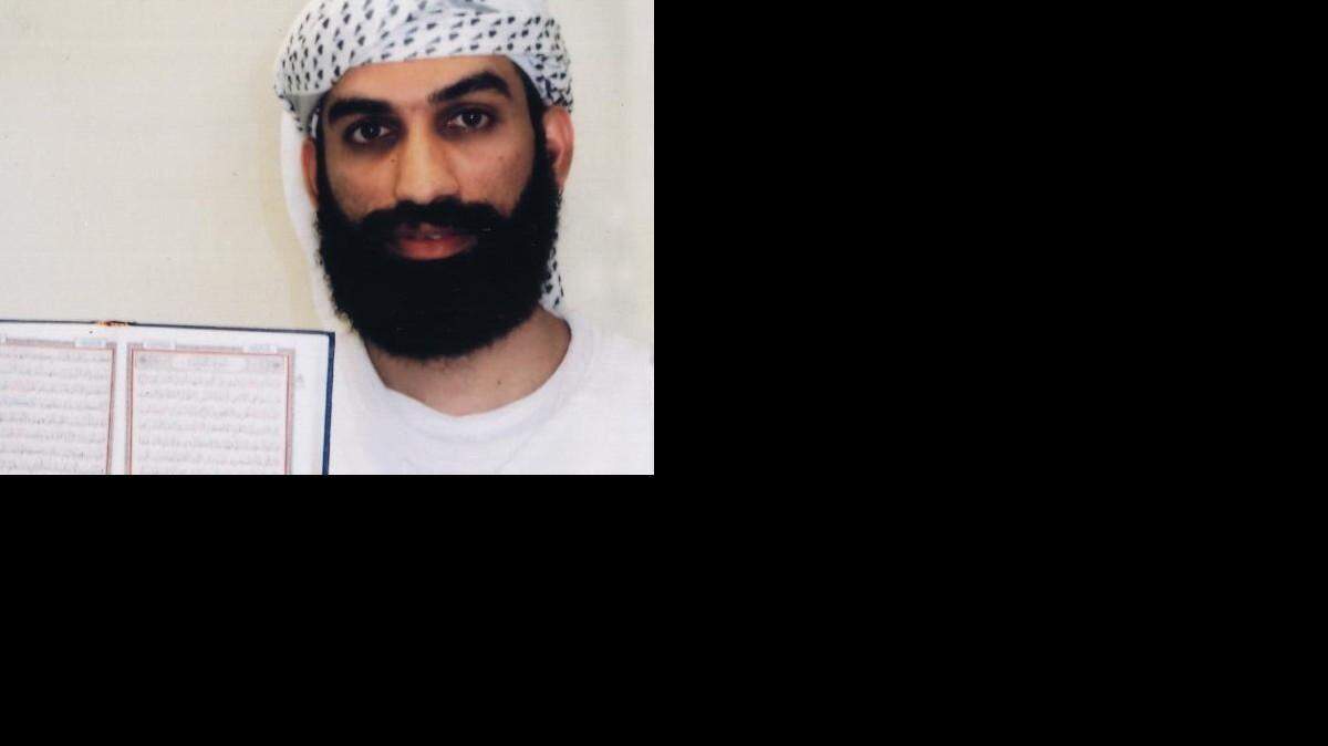Alleged al Qaeda lieutenant Ammar al Baluchi poses for the International Committee of the Red Cross in detention at Guantanamo. He is a nephew of Khalid Sheik Mohammed, and a self described "Microsoft-trained software engineer." He holds up a Koran whose page is too fuzzy to identify the sura, or chapter, inside in Camp 7, the secret detention center at Guantanamo Bay, Cuba, where former CIA detainees are segregated. The image offers a rare. if limited, look inside the prison camp run by a clandestine military team called Task Force Platinum.