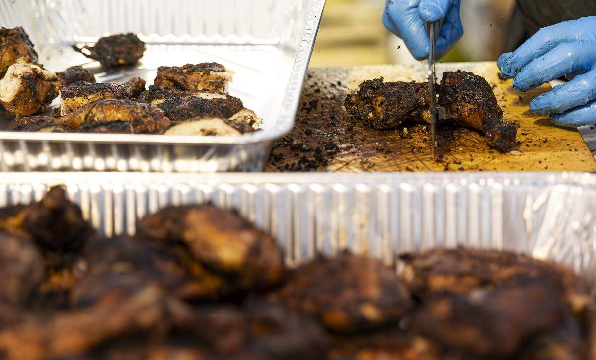 Chef Stephen Peralto, with One Stop Oasis, prepares jerk chicken for sale.
