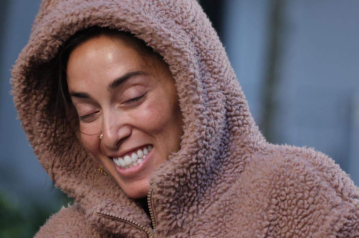 Nirvana resident Leela Sanikop, 37, reacts to cooler temperatures as she grins while dressed for the weather as temperatures drop due to arctic air on Tuesday, Nov. 11, 2025 in Miami, Florida.