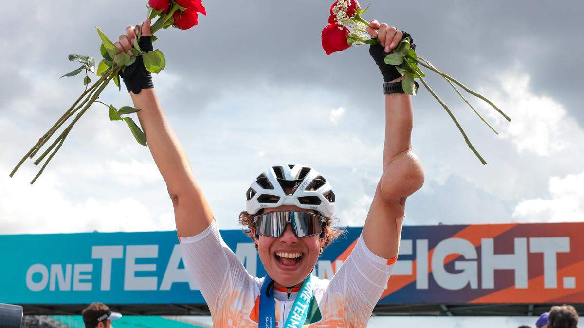 Ediana Albert, 51, who was diagnosed with a sarcoma in her left elbow, celebrates with red roses after finishing the 39-mile bicycle ride during the Dolphins Cancer Challenge XVI event at Hard Rock Stadium on Saturday, Feb. 28, 2026, in Miami Gardens, Florida.
