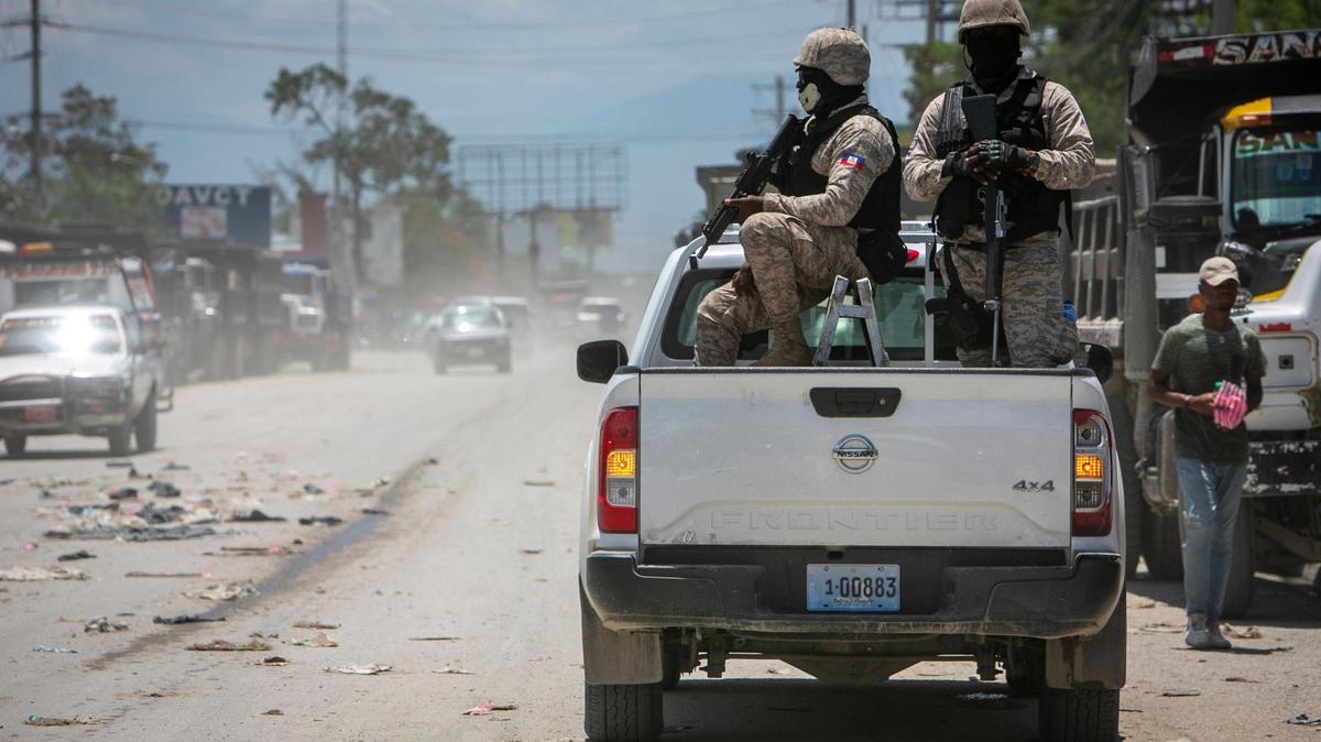 In 2022, Haiti police on patrol keep their eyes on traffic during a stop at a police checkpoint in Tabarre, near the U.S. Embassy, east of metropolitan Port-au-Prince. Gangs have taken control of neighborhoods in the vicinity.