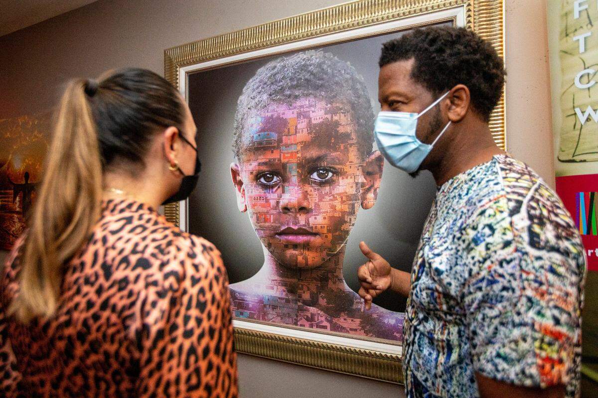 Haitian-American photographer Isaie “Zeek” Mathias, right, speaks with the Kimpton Angler’s Hotel general manager Sinem Kaya, left, as they discuss his artwork during an exhibit showcasing works by local Black artists during Black History Month. The exhibitions are at four Miami and Miami Beach Kimpton Hotels, which has partnered with the Greater Miami Convention & Visitors Bureau.