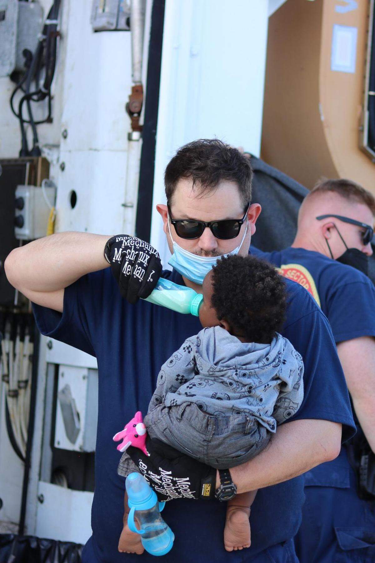 Coast Guard Cutter Campbell’s crew member feeding a baby near Anguilla Cay, Bahamas, April 11, 2022. Coast Guard Cutter Charles Sexton crew transferred 67 Haitians to Bahamian authorities after the Cutter Campbell crew stopped them.