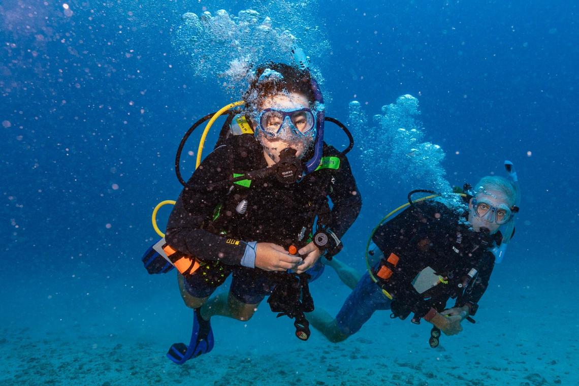 Master Diver Matteo Miller, 12, left, his father Paul Miller, right, swim at 70 feet during an ocean dive session on Friday, August 9, 2024, in Key Biscayne, Fla. Miller received the Master Diver certification after completing his Rescue diver certification.