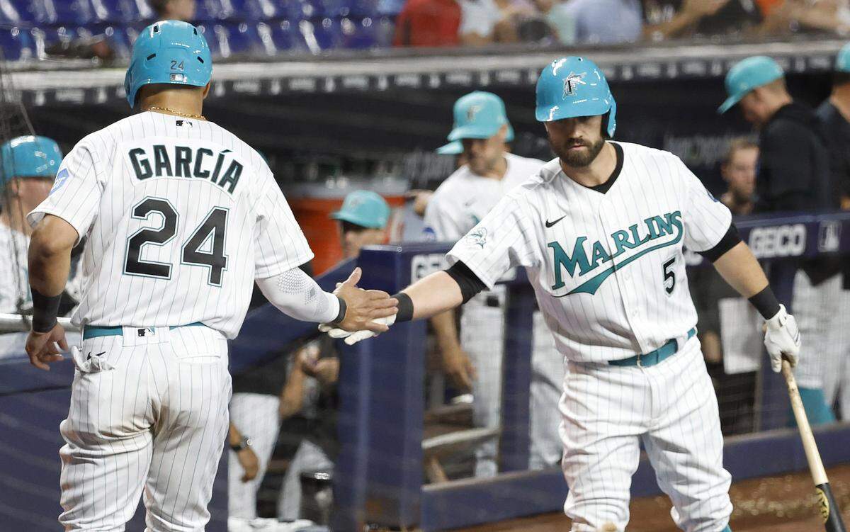 Miami Marlins right fielder Avisail Garcia (24) is congratulated by third baseman Jon Berti (5) after scoring a run against the Arizona Diamondbacks during the fifth inning at loanDepot Park on Friday, April 14, 2023.