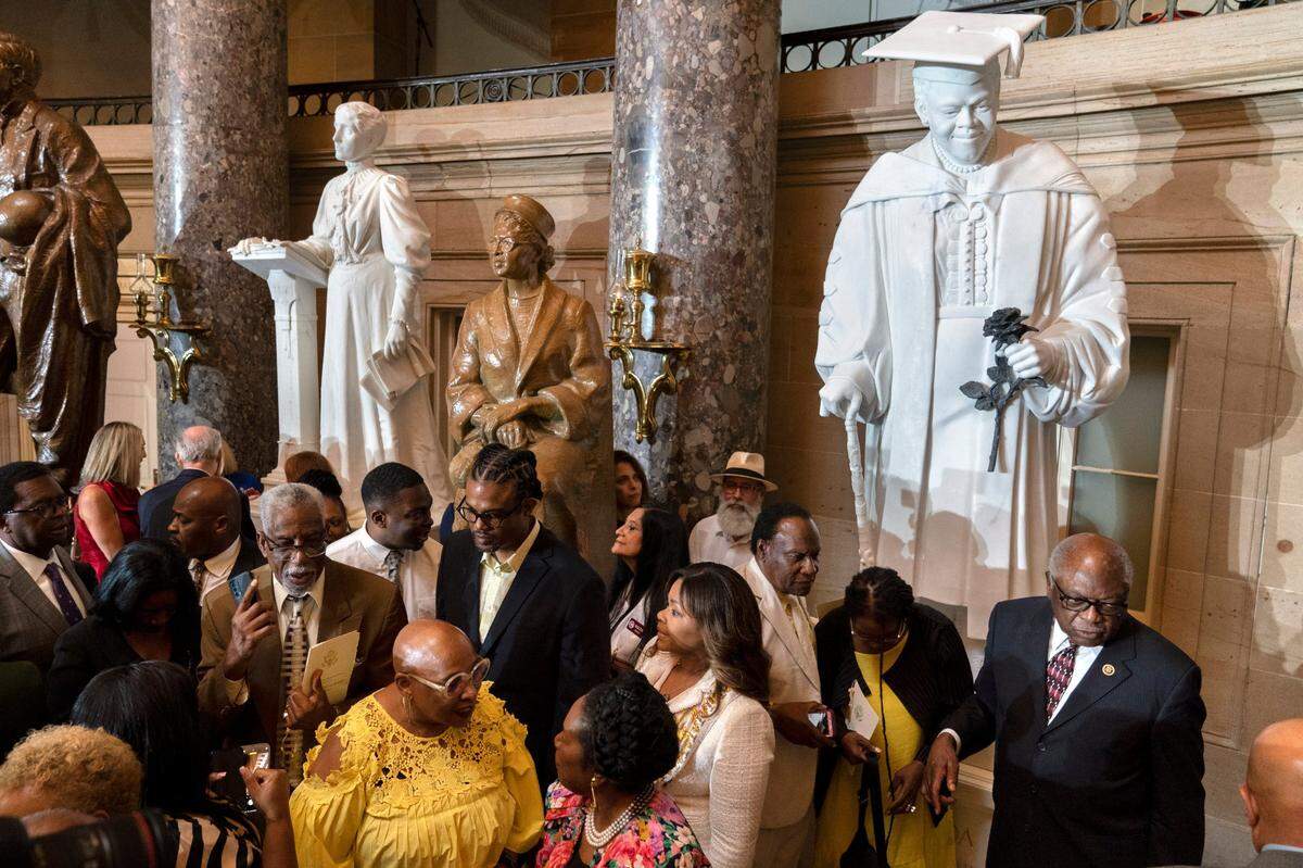 Evelyn Bethune, front left in yellow, a granddaughter of Mary McLeod Bethune, speaks with Rep. Sheila Jackson Lee, D-Texas, as members of the Congressional Black Caucus gather around an unveiled statue of Mary McLeod Bethune, at a ceremony for the statue, which is the first state statue of a Black woman in Statuary Hall, Wednesday, July 13, 2022, at the U.S. Capitol in Washington.