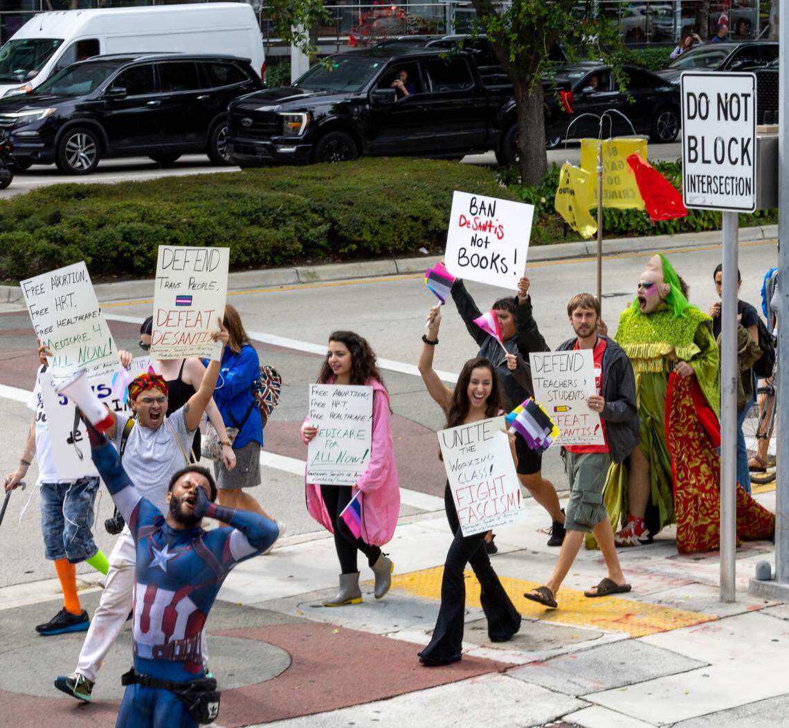 Protesters against Gov. Ron DeSantis and his policies get loud on the sidewalk outside the Four Season Miami on Brickell Avenue on Wednesday, May 24, 2023, while DeSantis supports gather inside for the first official function of his presidential campaign.