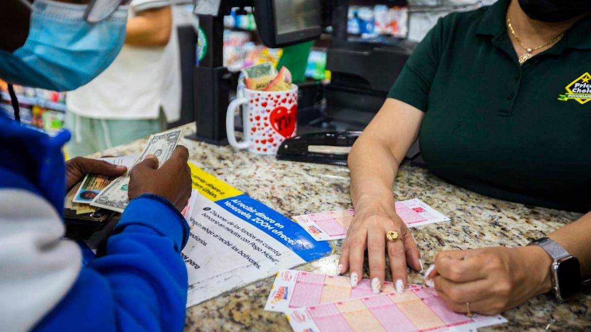 Mary Joseph, gets Lotto Tickets from Yolanda Vindel, right, at PriceChoice Supermarket Edgewater when Mega Millions Jackpot the Lottery in Florida; Miami, July 29, 2022.