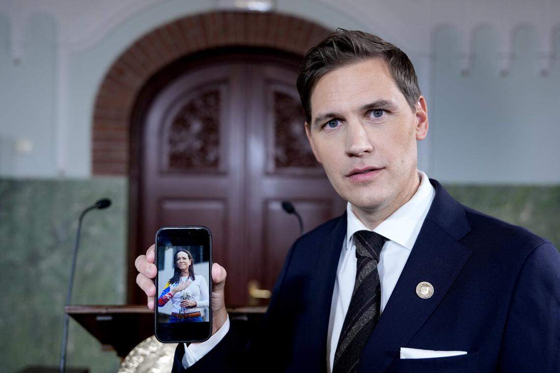 Jorgen Watne Frydnes, the chair of the Norwegian Nobel Committee, holds his smartphone with a photo of Venezuelan opposition leader María Corina Machado, the winner of the 2025 Nobel Peace Prize at the Norwegian Nobel Institute in Oslo, Norway, on October 10, 2025. 