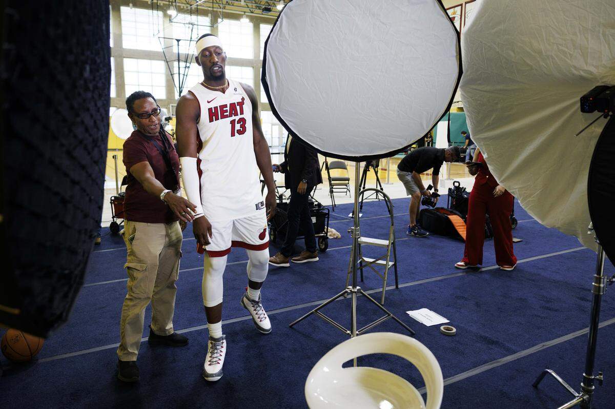 Bam Adebayo (13) walks onto the set with Miami Herald photographer Carl Juste during the Miami HEAT Media Day on Monday, Sept. 29, 2025, at the Kaseya Center in downtown Miami, Fla.