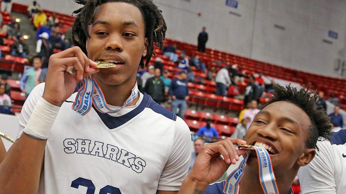 University School Scottie Barnes (32) and Xavien Flowers (10) bite their medals after they defeated Andrew Jackson in the 5A Boy’s Finals State Basketball Championships at the RP Funding Center in Lakeland, Florida, Thursday, March, 7, 2019.