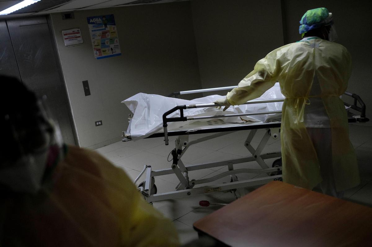 A health worker pushes a gurney with the body of a COVID-19 victim to the morgue at the Ana Francisca Pérez de León II public Hospital in Caracas, Venezuela, on March 23, 2021.