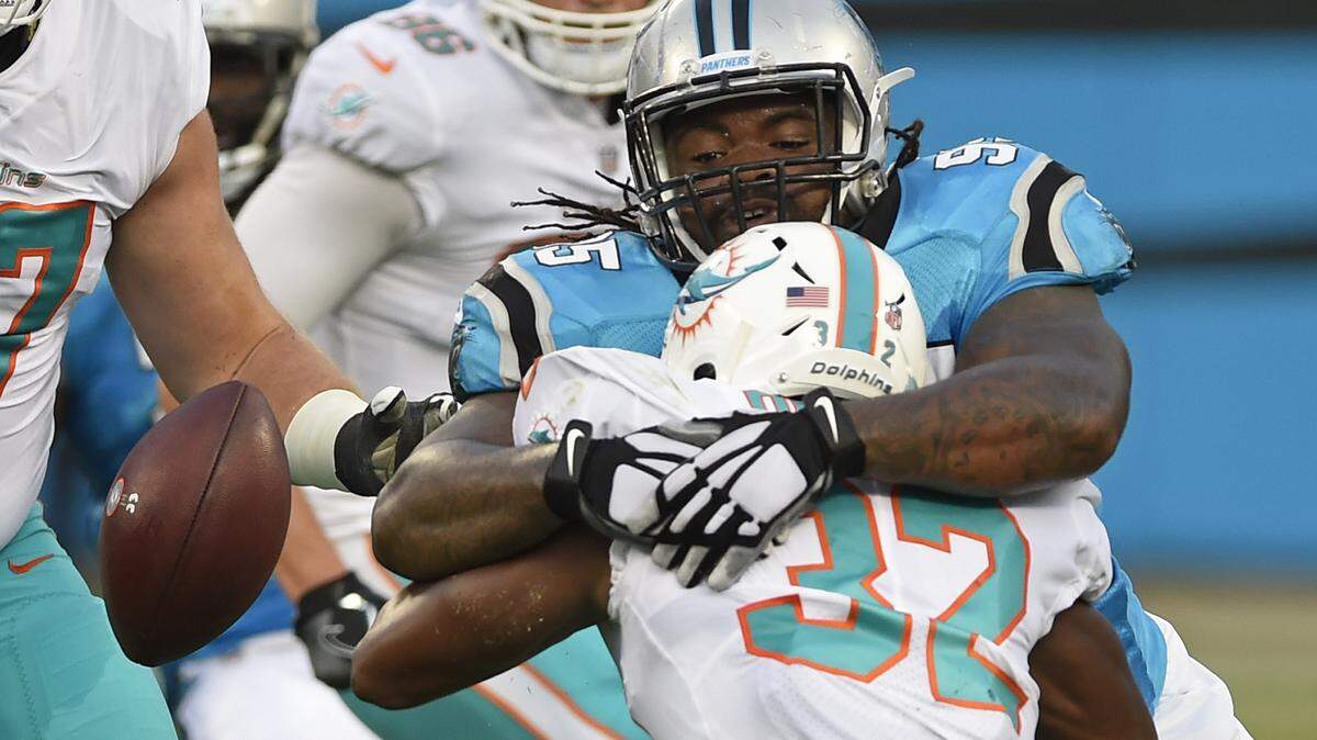 Miami Dolphins running back Kenyan Drake fumbles the ball as he is hit by Carolina Panthers’ Dontari Poe Friday night.