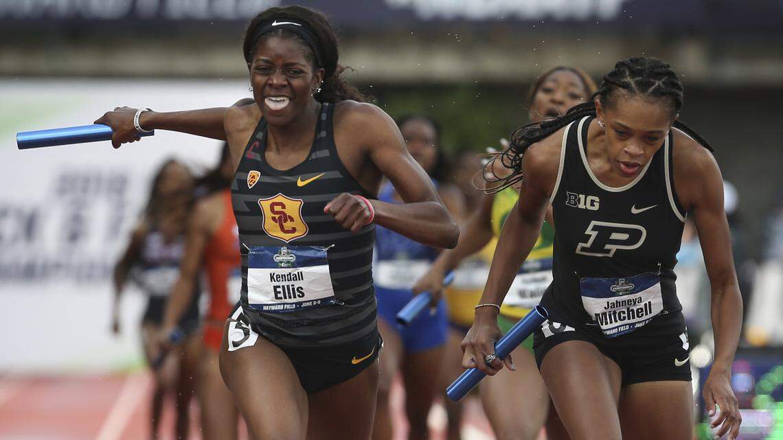 Southern California's Kendall Ellis, left, crosses the finish line first in the women's 1,600 relay, next to Purdue's Jaheya Mitchel on the final day of the NCAA Outdoor Track and Field Championships at Hayward Field on Saturday, June 9, 2018, in Eugene, Ore.