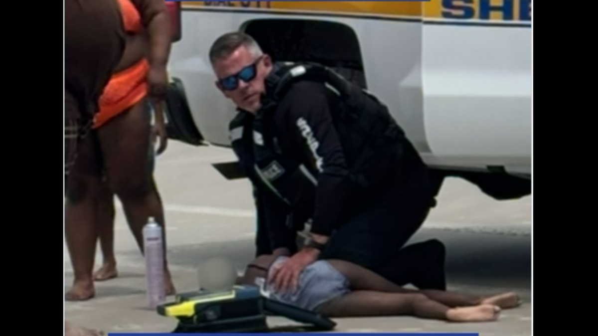 This photo shows Officer Billy Crocker tending to an 8-year-old girl who was pulled unconscious from the Atlantic Ocean off Jacksonville, Florida, the Jacksonville Sheriff’s Office says. She was taken to a hospital and survived, officials say.