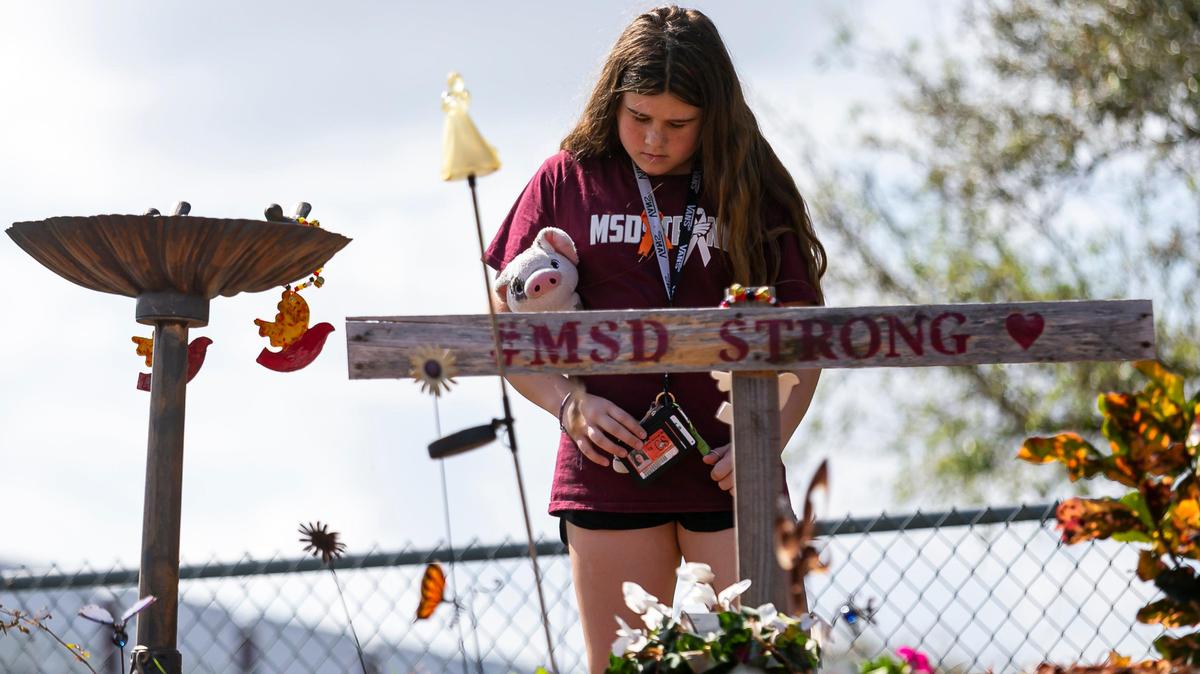 Cayley Clemo, 13, a Coral Springs Middle School student, visits a makeshift memorial outside of Marjory Stoneman Douglas High School on Friday, February 14, 2020, on the two-year anniversary of the Parkland shooting where 17 victims were killed. The Broward School Board, responding to a lawsuit filed by the Parkland parents whose children died in the shooting, is seeking psychiatric records from the parents to prove mental anguish, the Sun Sentinel reported.