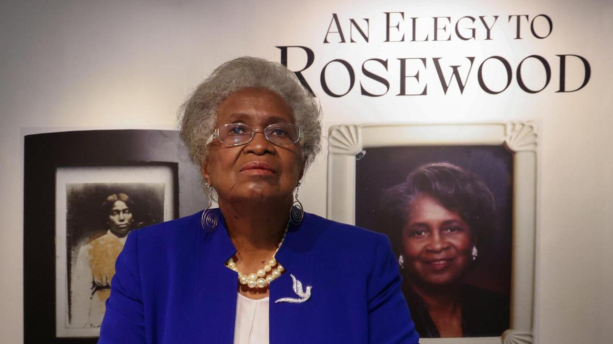 Lizzie Robinson Jenkins is photographed in front of portraits of her grandmother and herself, part of the exhibition ‘An Elegy to Rosewood,’ in commemoration of the 100-year anniversary of the Rosewood Massacre, at FIU’s Frost Art Museum.