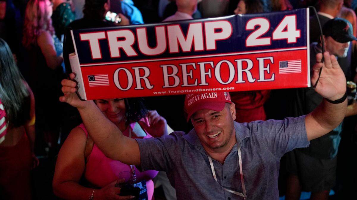 A man holds a sign before Florida Republican Gov. Ron DeSantis speaks to supporters during an election night party, in Tampa, Florida on Nov. 8.