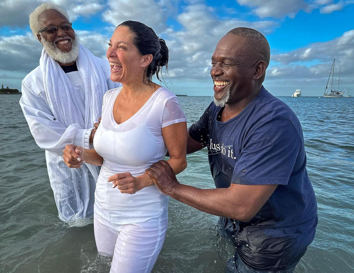 Jacqueline DeFrancesco, 57, of Kendall, smiles in joy after being baptized by Minister Allen Mushgrove, left, and Apostle Leon Everett, right, and in the Biscayne Bay off Hobie Beach. Jesus Christ True Church celebrated a remarkable milestone by baptizing over 40 individuals at Hobie Beach on Easter Sunday, April 20, 2025, in Miami, Florida. Founded in 1986, the small Liberty City church continues its mission to uplift the Miami-Dade community, warmly welcoming everyone, regardless of their background or circumstances.