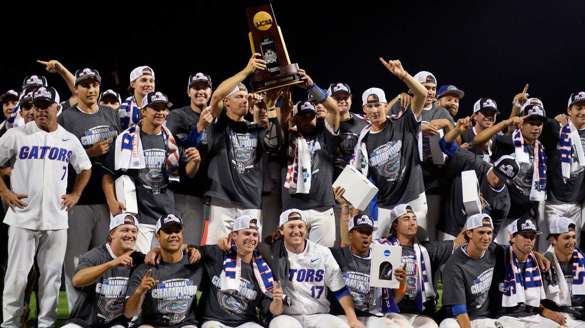 Florida players celebrate with the trophy after defeating LSU in Game 2 to win the NCAA College World Series baseball finals in Omaha, Neb., Tuesday, June 27, 2017.