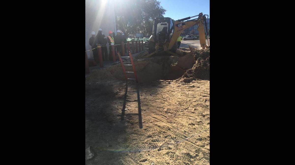 Gainesville Fire Rescue crews used a ladder to get inside a 10-foot by 25-foot hole into which a construction worker fell and was completely buried on Jan. 10, 2019.