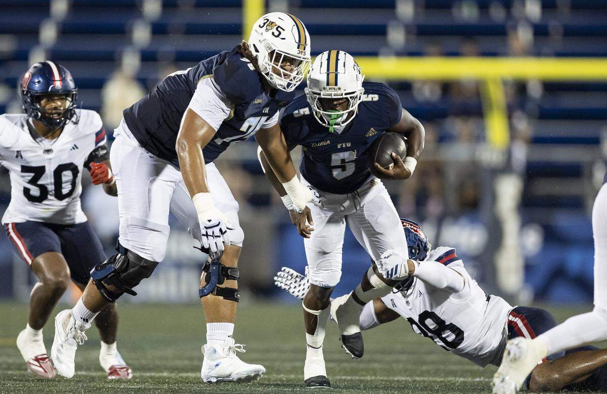 FIU Panthers running back Kejon Owens (5) runs with the ball as Florida Atlantic University Owls linebacker Zyere Horton (28) goes to tackle in the first half of their Shula Bowl football game at Pitbull Stadium on Saturday, Sept. 13, 2025, in Miami, Fla.