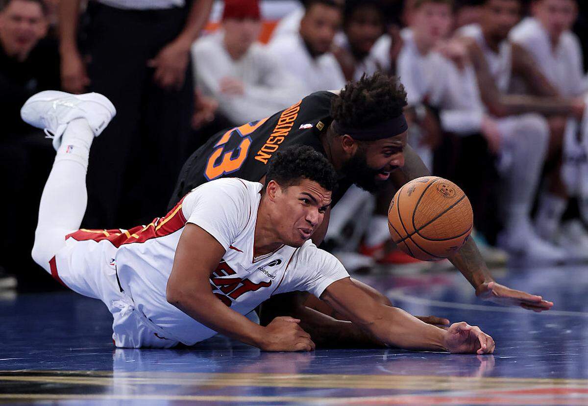 Dru Smith #12 of the Miami Heat and Mitchell Robinson #23 of the New York Knicks go after the loose ball in the second half at Madison Square Garden on November 14, 2025 in New York City.