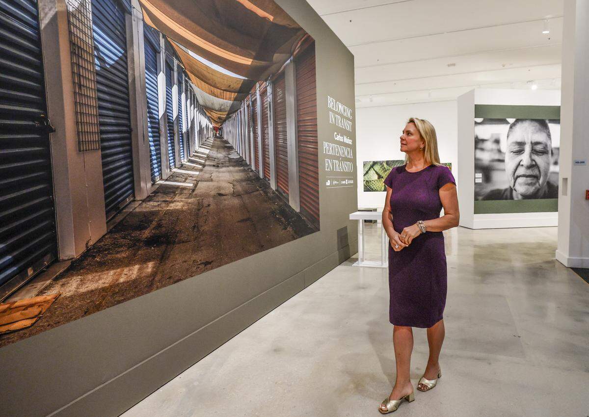 Michelle Reese Granger, Senior Director of Marketing at HistoryMiami walks through the "Belonging in Transit" photography exhibition by Venezuelan-born artist Carlos Muñozis at the museum on Wednesday, May 6, 2026. The museum is changing its name to Museum of Miami and is starting a new "museum without walls" initiative where they show exhibitions across Miami Dade County.