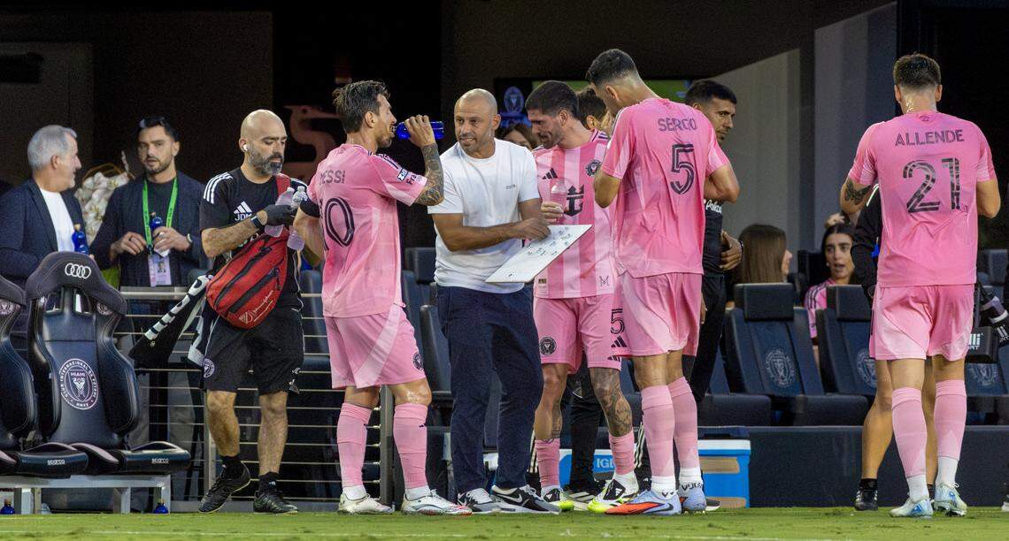 Inter Miami head coach Javier Mascherano gives instructions to forward Lionel Messi (10), midfielder Sergio Busquets (5), and midfielder Rodrigo De Paul (7) during a hydration timeout in the first half of a Leagues Cup Phase One match against Atlas at Chase Stadium, Wednesday, July 30, 2025, in Fort Lauderdale, Fla.