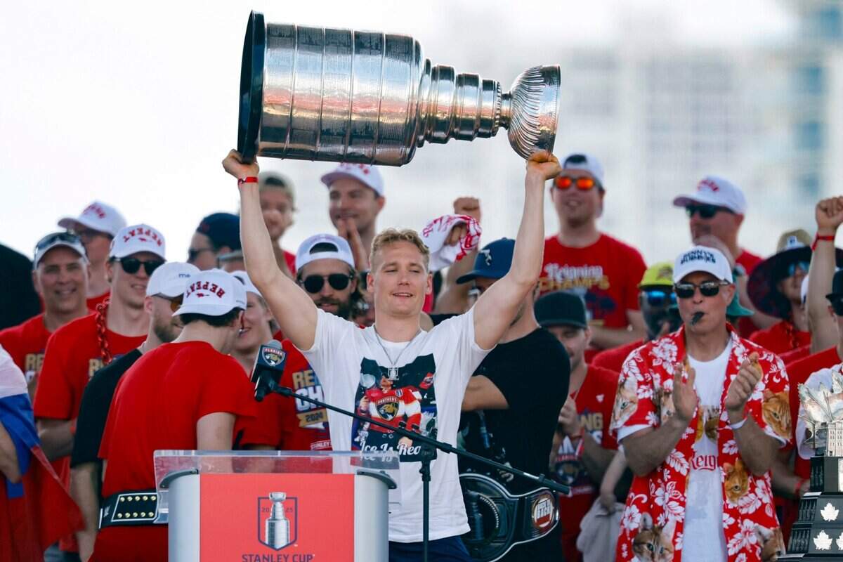 Florida Panthers defenseman Gustav Forsling hoists the Stanley Cup as teammates celebrate on stage during the team’s victory parade and rally along A1A in Fort Lauderdale, Florida, on Sunday, June 22, 2025